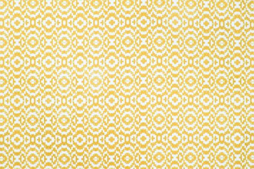 Echo Printed Fabric in Lemon, featuring a soft yellow ikat-inspired circular pattern on natural linen, adding brightness and movement to interiors.