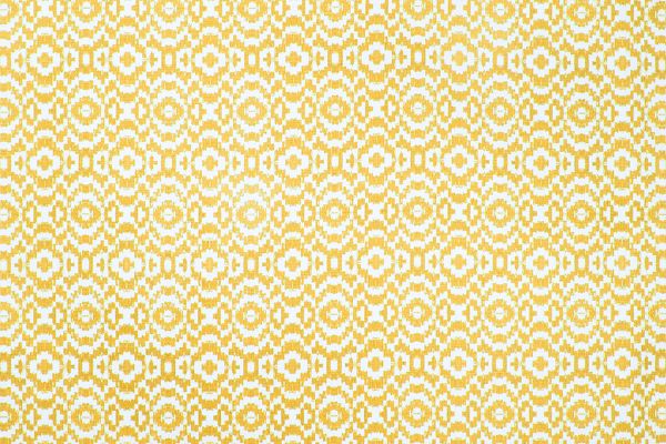 Echo Printed Fabric in Lemon, featuring a soft yellow ikat-inspired circular pattern on natural linen, adding brightness and movement to interiors.