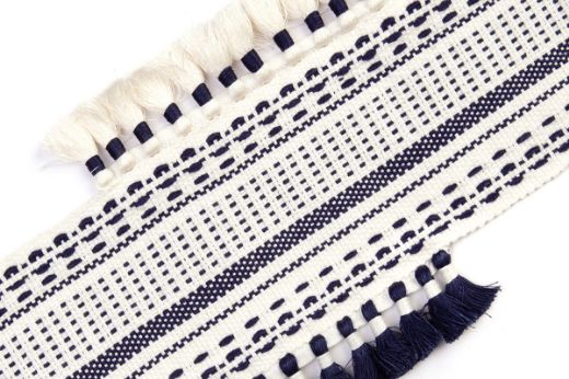 Pom Parade Border Trim in dark indigo — deep navy blue stitched border with sporadically placed tasselled trims in contrasting white.
