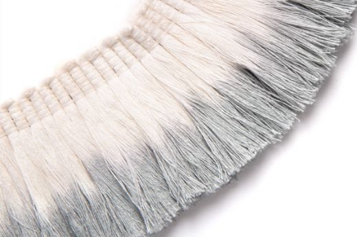 Soft pale blue dip-dyed fringe trim on natural linen, offering a light, airy ombré finish.