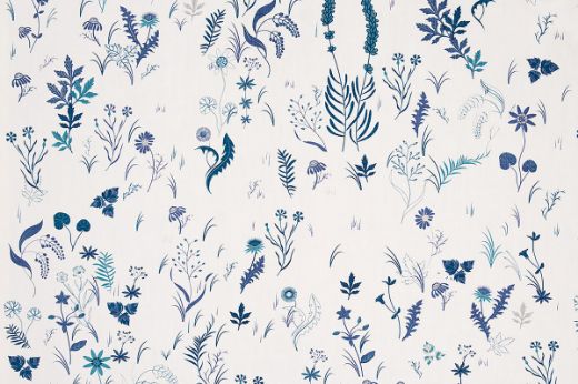 Deep indigo botanical fabric on white linen cloth, showcasing intricate garden-inspired illustrations by designer Tord Boontje.