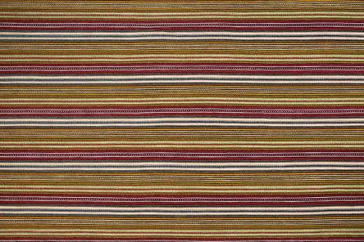 A multicoloured woven stripe design with dominant lime green tones, featuring rich textural variation and vibrant accents within a fresh, earthy palette.