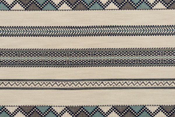 Woven fabric in dark blue, indigo and natural tones. Has zig zag motif stripes running horizonal.