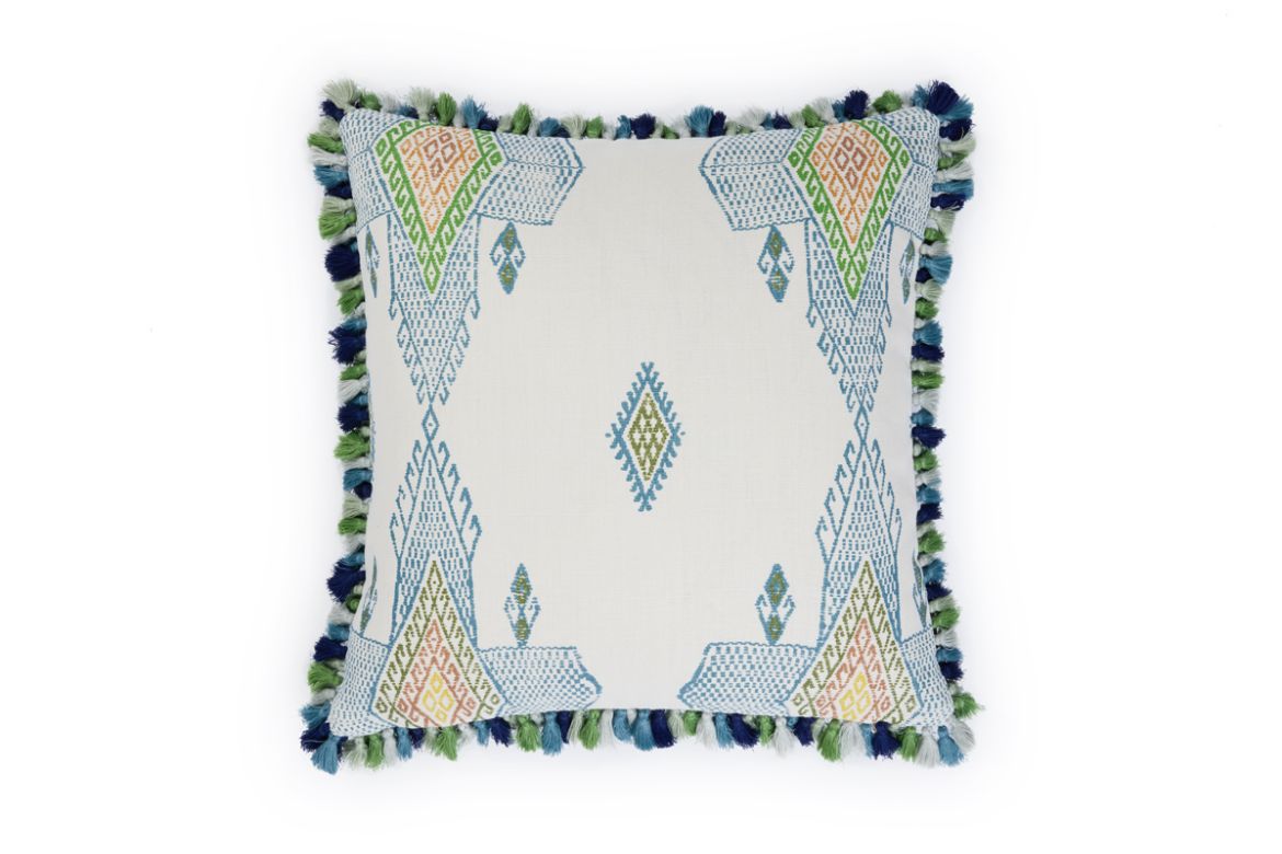 Front view of Travelling Light Teal cushion featuring vibrant teal, green, and blue geometric and triangle patterns with yellow and orange accents, finished with green Jamboree fringe trim.